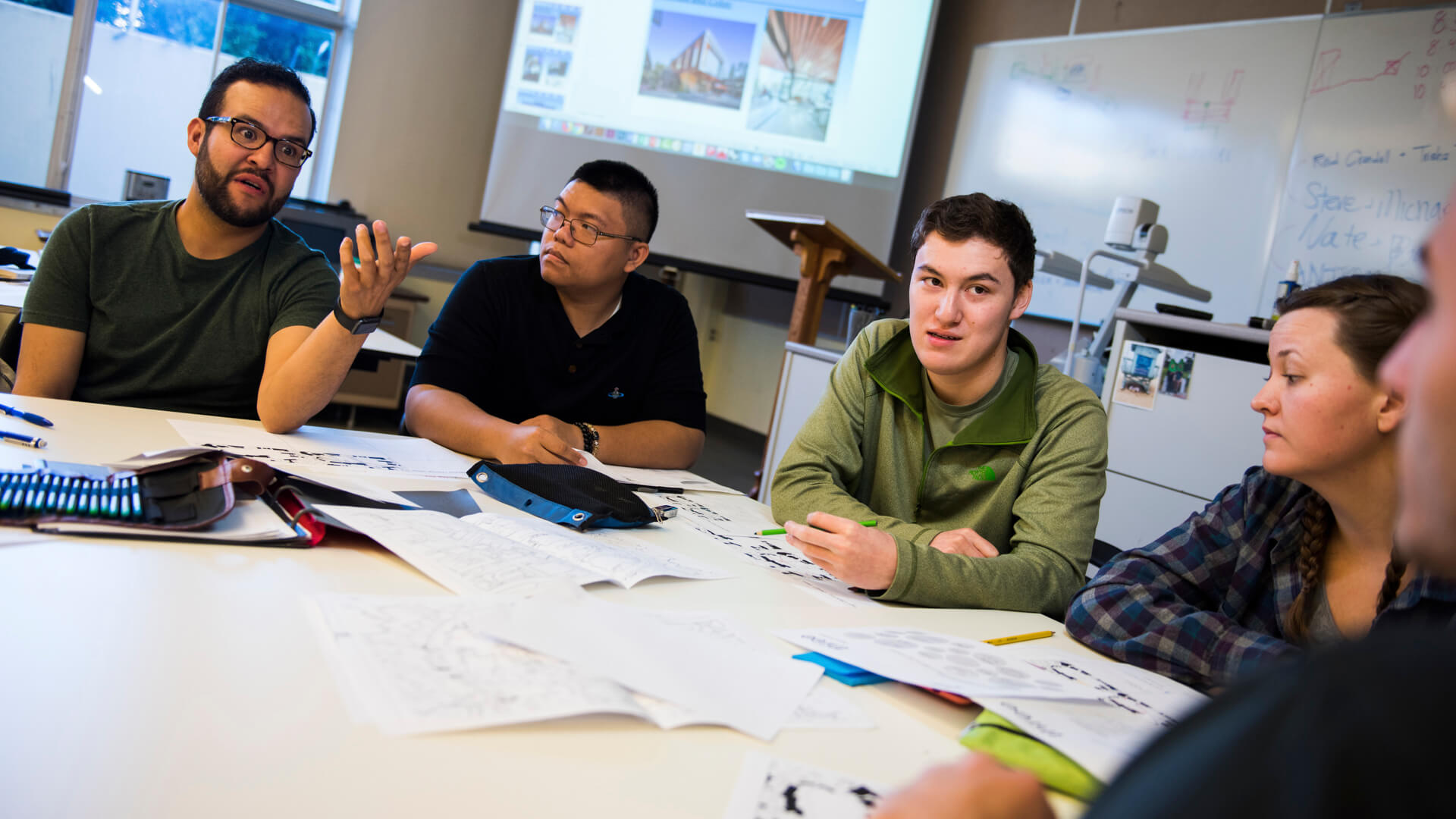 CAED students sitting together at a table within a classroom workign on a project